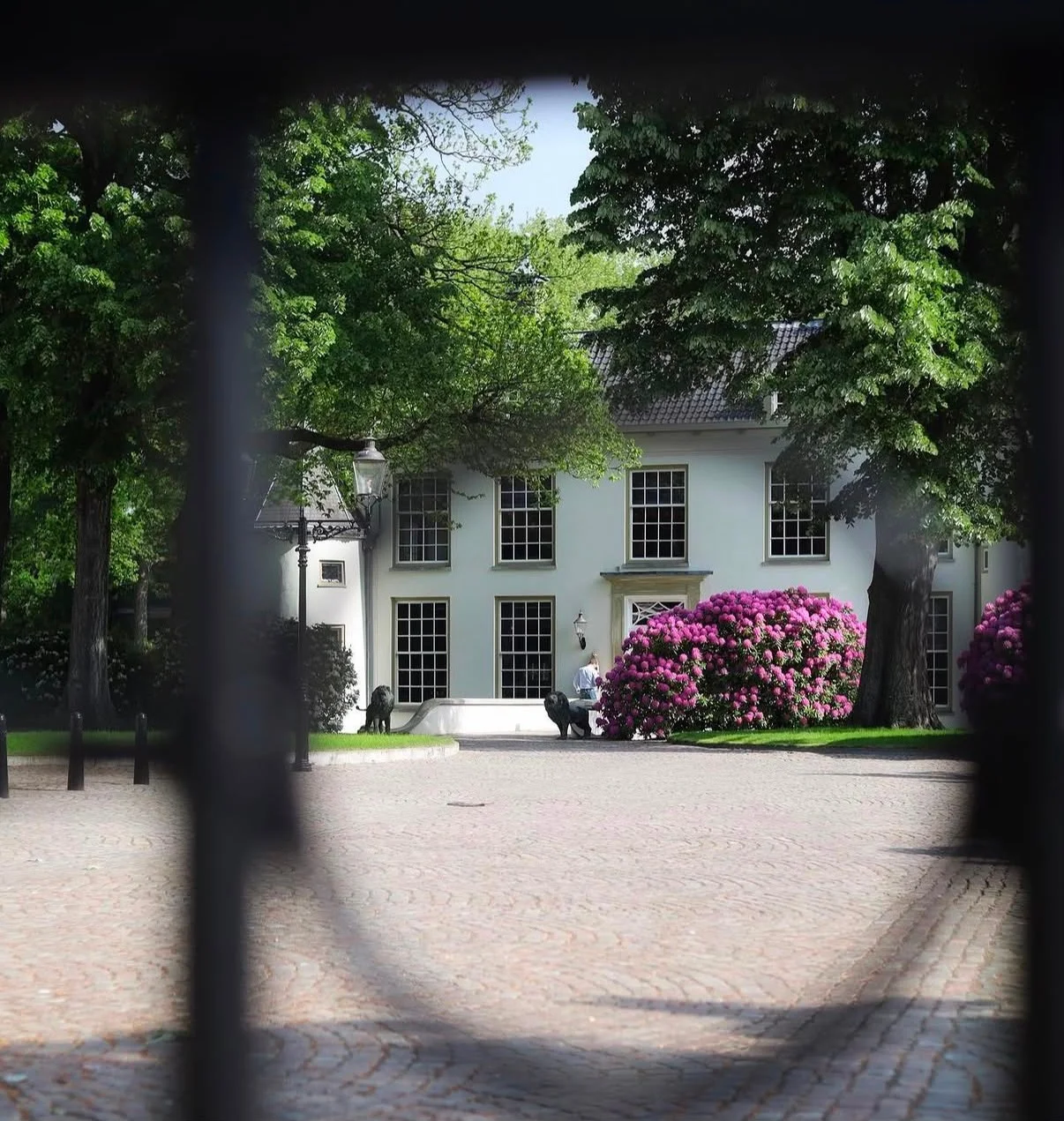 Wit landhuis achter een poort in Oosterhout